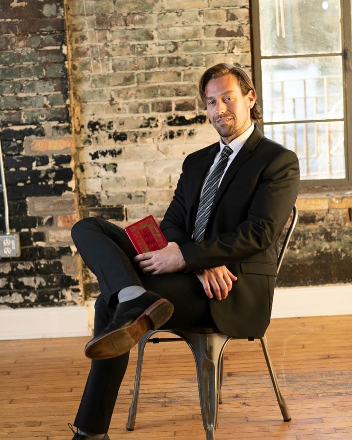 a man in a suit sitting on a chair