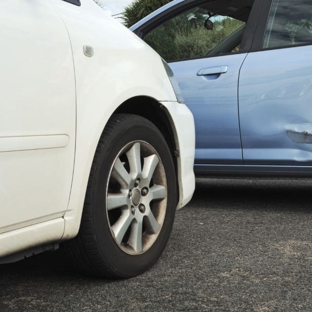 a white car with a dent in the side of it