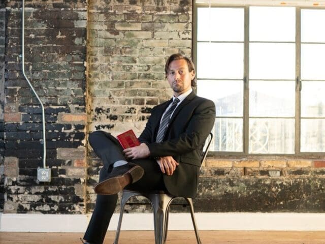 a man sitting on a chair with his legs crossed