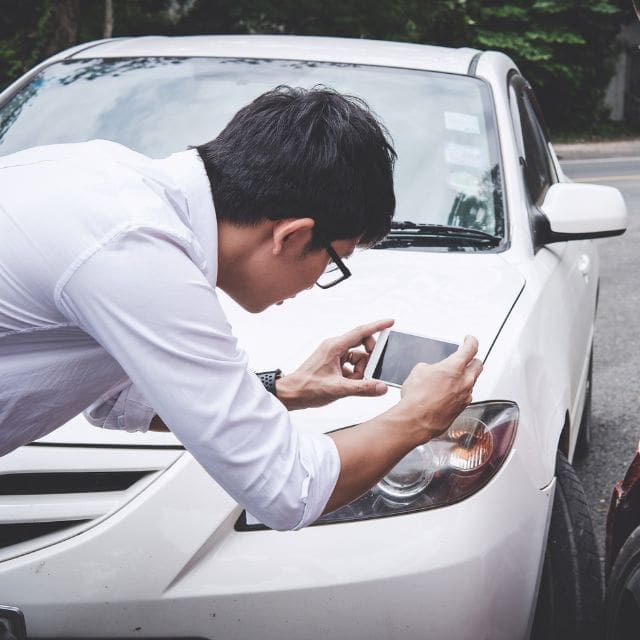 man taking a picture of his car