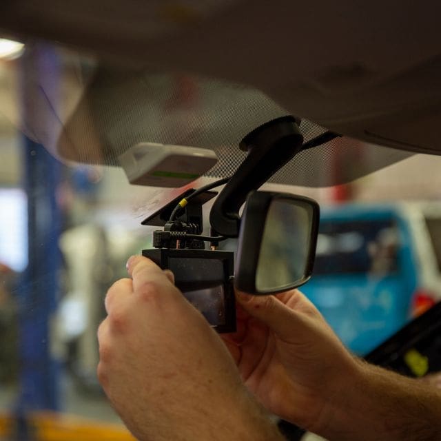 hands fixing a car dashcam 