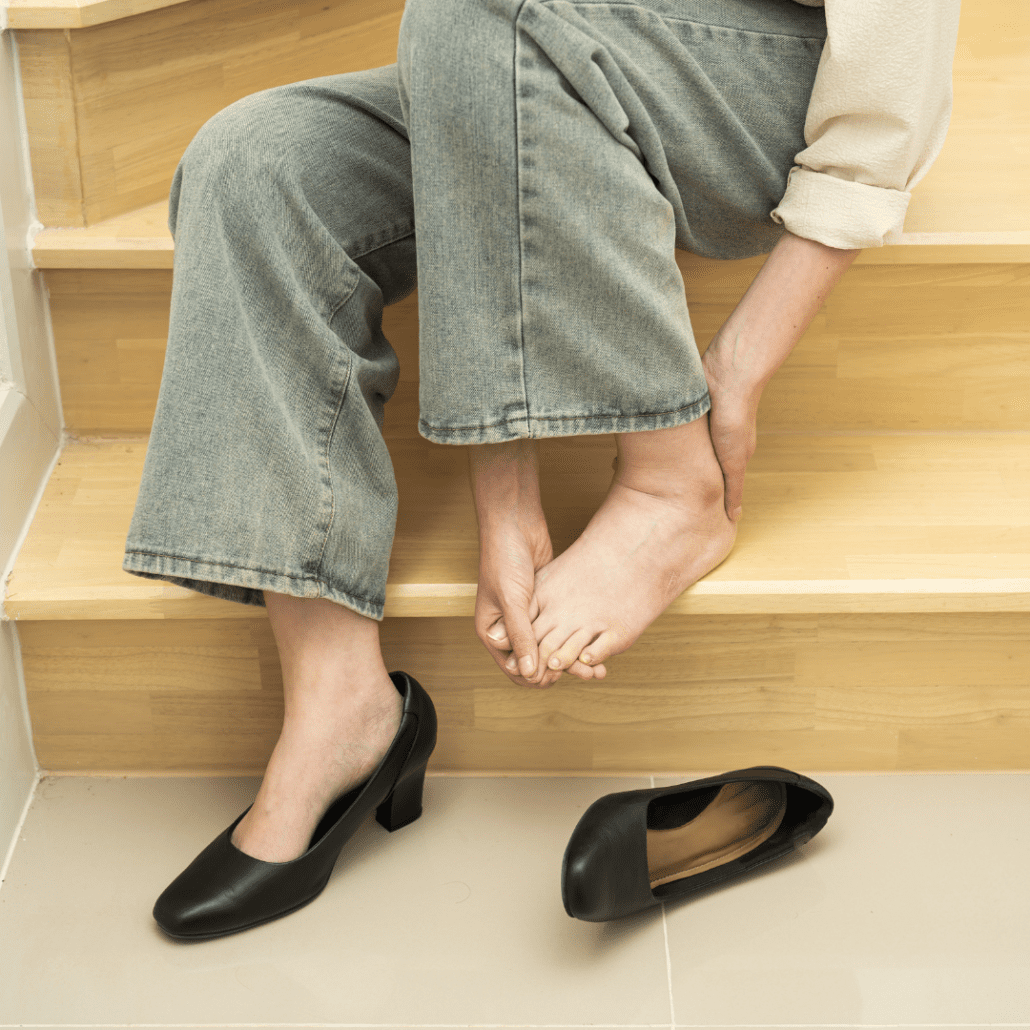 woman sitting on the stairs with her shoe off